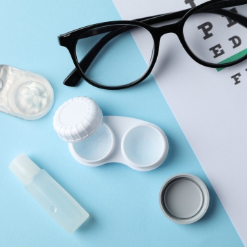 Glasses, contact lenses and eye test chart on blue background, t