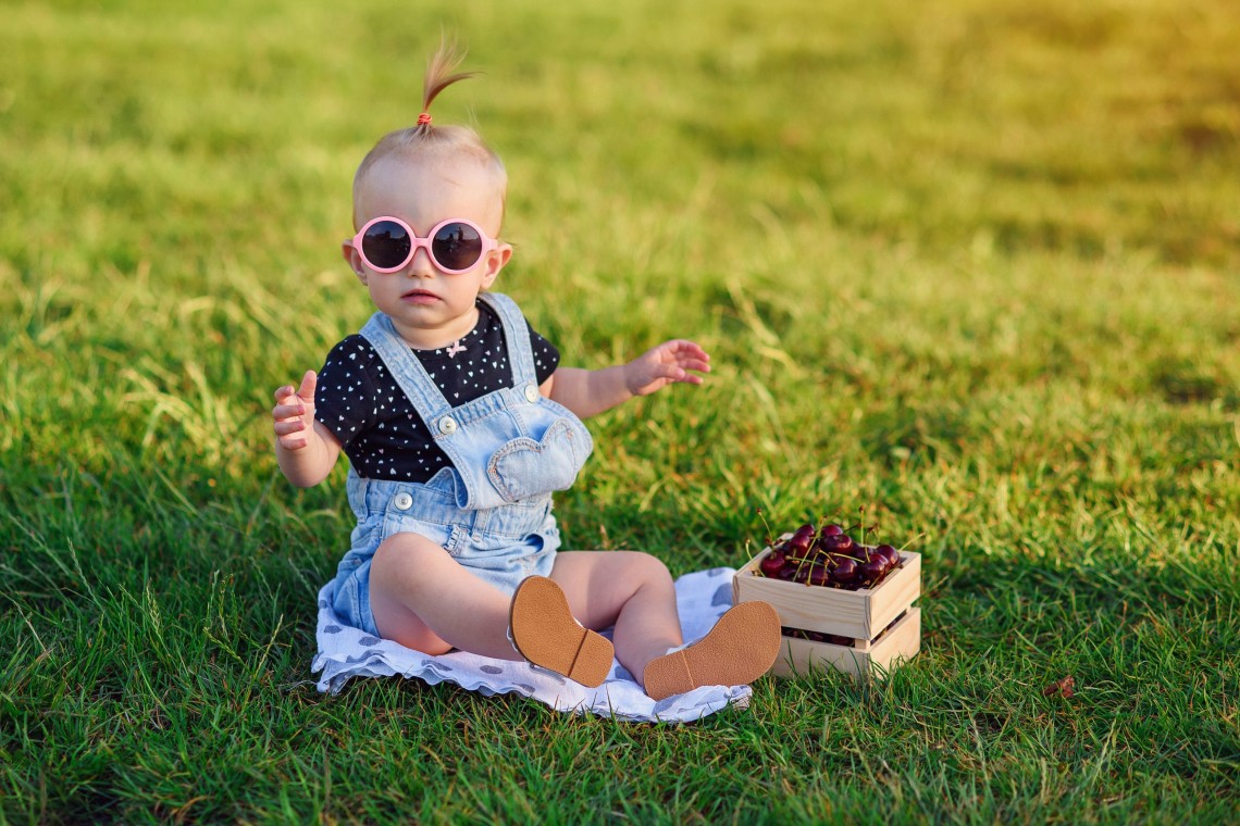 Adorable little girl in stylish pink sunglasses and denim clothe